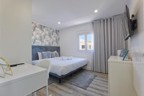 a white bedroom with a bed and a window at Vita Portucale ! Santa Clara Terrace & Jacuzzi in Lisbon