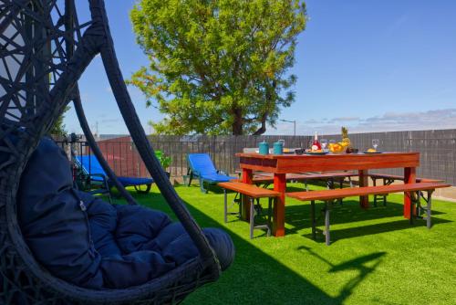 a hammock swing in a yard with a table and chairs at Vita Portucale ! Santa Clara Terrace & Jacuzzi in Lisbon