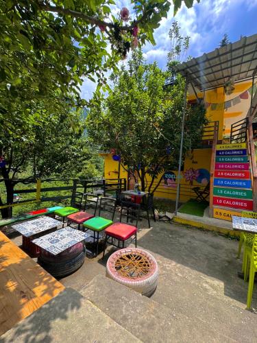 a group of tables and stools in front of a building at Zoella in Gushaini