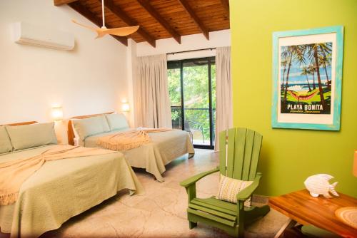 a bedroom with two beds and a chair and a table at Central Hotel Boutique in Las Galeras