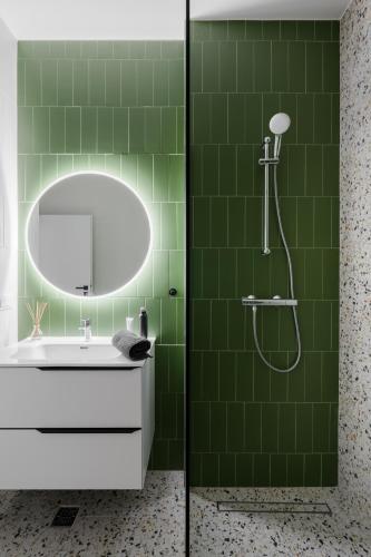 a green tile bathroom with a sink and a shower at AXXIS Apartments by AXXIS Nova Resort&SPA in Mamaia