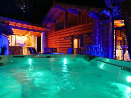 - une grande piscine en face d'une maison la nuit dans l'établissement Cabane de Rêve, à Montmurat