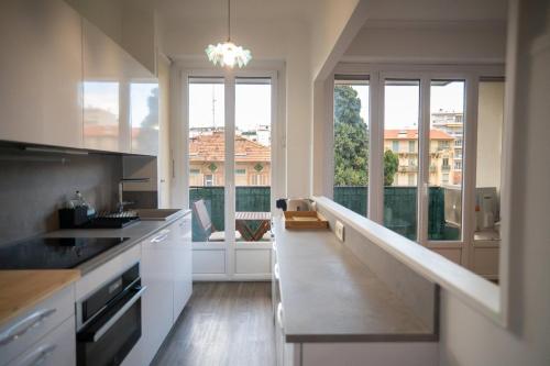 une cuisine avec des placards blancs et une grande fenêtre dans l'établissement GuestReady - Modern comfort near Nice market, à Nice