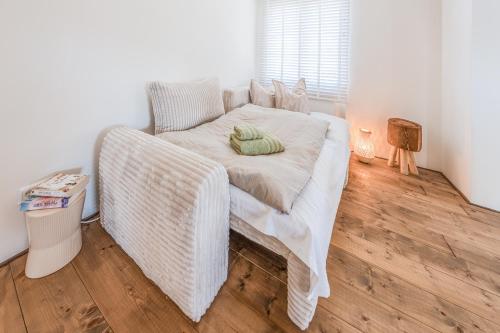 a bed in a room with a wicker couch at Seeapartment Panorama in Gaienhofen