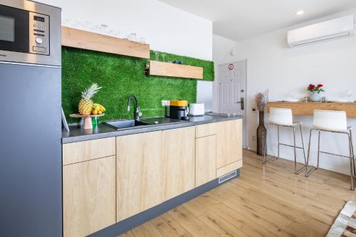 a kitchen with a sink and a green wall at BalatonGardens Apartman in Balatonudvari