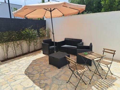 een patio met een parasol en een tafel en stoelen bij La Casa del Borgo in Lecce