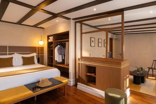 a bedroom with a bed and a desk in a room at Hotel Le Colombier in Obernai