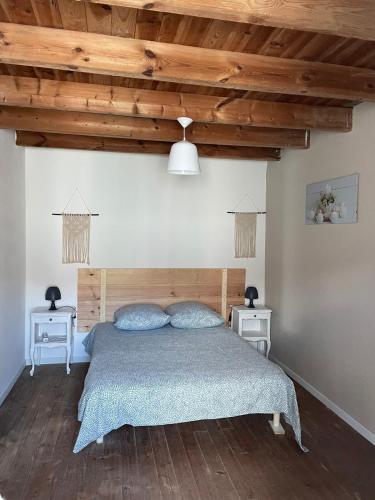 une chambre avec un lit et deux tables de nuit dans l'établissement Charmante maison de village 30 min Puy DuFou, à Bazoges-en-Pareds