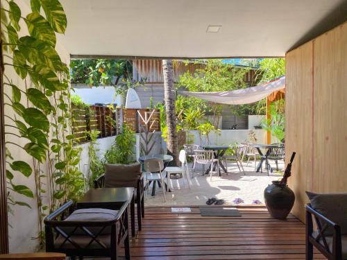 a patio with a table and chairs and a patio with plants at Tropika Beach Thulusdhoo in Thulusdhoo