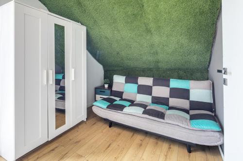 a room with a couch in a room with a mirror at BalatonGardens Apartman in Balatonudvari