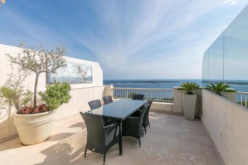 un balcon avec une table et des chaises et l'océan dans l'établissement REF 1969 - Cannes - Penthouse with panoramic sea view for rent, à Cannes