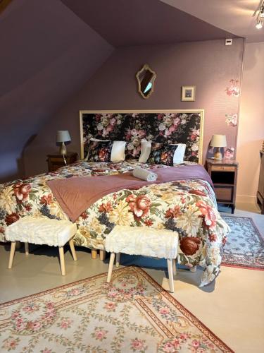 a bedroom with a large bed with a floral bedspread at Domaine familial du château de Ragny in Savigny-en-Terre-Plaine