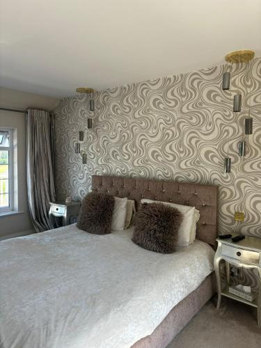 a bedroom with a bed with a patterned wall at Brig o Doon 2 in Ayr