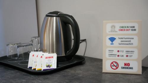 a tea kettle sitting on a counter next to a box at Hotel LUMINOSA in Shkodër