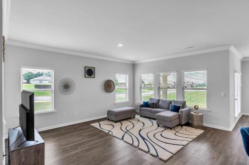 a living room with a couch and a tv at Charming 4BR Ranch-Style Home - Corner Lot home in Harvest