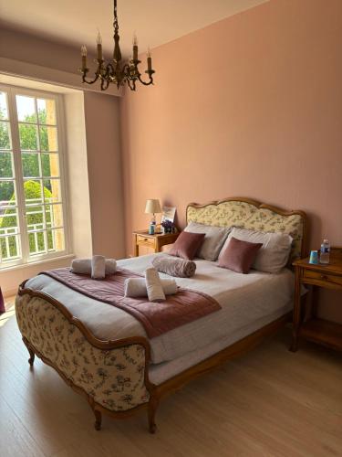a bedroom with a large bed with a chandelier at Domaine familial du château de Ragny in Savigny-en-Terre-Plaine