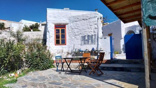a table and chairs in front of a white building at Clive and Bifi's house in Lachania