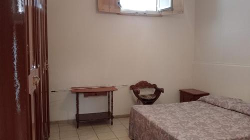 a bedroom with a bed and a table and a window at Casa David in Cava deʼ Tirreni
