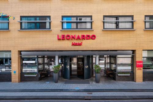 a large brick building with a sign for a flower shop at Leonardo Hotel Hengelo City Center in Hengelo