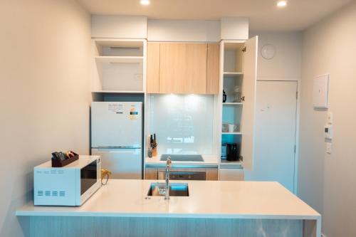 a kitchen with a sink and a refrigerator at The Edgerley Suites in Auckland