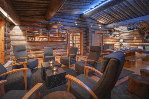 a room with chairs and tables in a log cabin at Kuukkeli Log Houses Aurora Resort in Saariselka