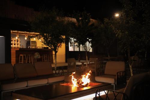a fire pit in the middle of a patio at night at Plis Bujtina - Guesthouse in Kolgecaj