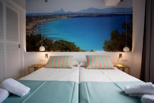 a bedroom with a bed with a view of the ocean at Apartamentos Pou Des Pujols in Es Pujols