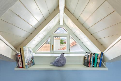 a window in a room with books and a vase on a shelf at Casa della Musica in Verbania