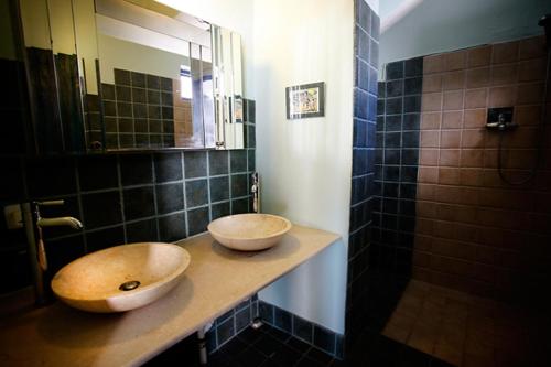 a bathroom with two sinks on a counter with a mirror at Clive and Bifi's house in Lachania