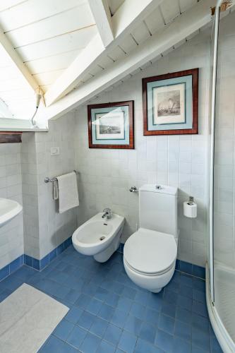 a white bathroom with a toilet and a sink at Casa della Musica in Verbania