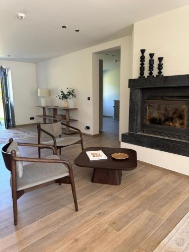 a living room with a fireplace and a table and chairs at La Barzalière in Chimay