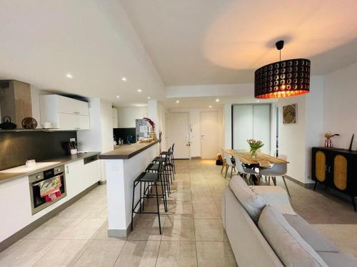une cuisine et un salon avec un canapé et une table dans l'établissement Bel Appartement lumineux avec balcon, au Cannet