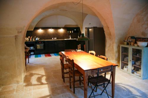 une cuisine avec une table en bois et quelques chaises dans l'établissement La Meillerie, cozy villagehouse, à Sanilhac-et-Sagriès