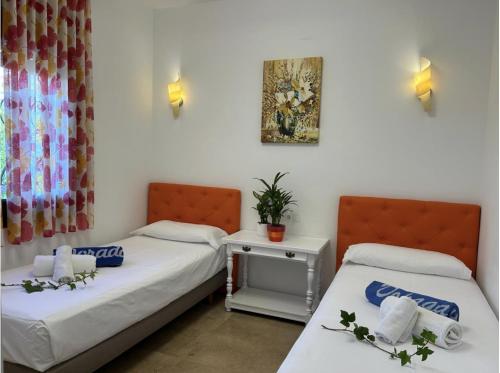 a room with two beds and a table at Pino Alto Villa Jazmin in Miami Platja