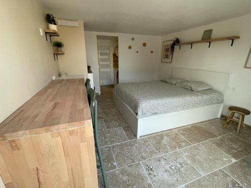 a bedroom with a bed and a wooden table at Carpe Diem in Toulon