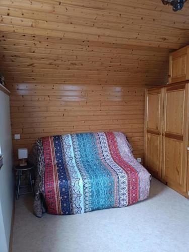 a bedroom with a bed in a wooden room at STUDIO Monnet in Antrenas