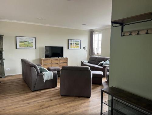a living room with couches and a flat screen tv at Feriendomizil im Saarschleifenland in Mettlach