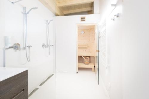 a white bathroom with a shower and a sink at Sport Chalet Maria Alm in Maria Alm am Steinernen Meer