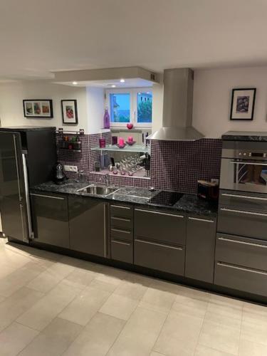 une cuisine avec un évier et une cuisinière dans l'établissement Appartement rénové T3 en duplex, à Argelès-Gazost