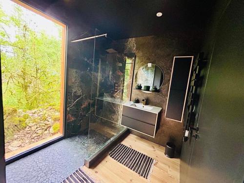 une salle de bain avec une douche et un lavabo et une fenêtre dans l'établissement La Cabane du Prestadou - Bain nordique et Sauna, à Arcambal