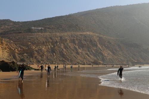 a group of people walking on the beach at SurfAppart Morocco in Tamraght Ouzdar