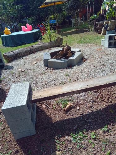 a garden with a fire pit in the yard at Chácara com acesso à represa in Ibiúna