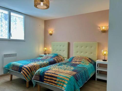 une chambre avec deux lits et deux lampes et une fenêtre dans l'établissement Appartement avec terrasse, 2 chambres, proche plage - 4 pers - FR-1-494-198, à Royan