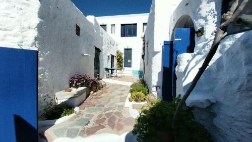 an alley with white buildings and a blue door at Clive and Bifi's house in Lachania