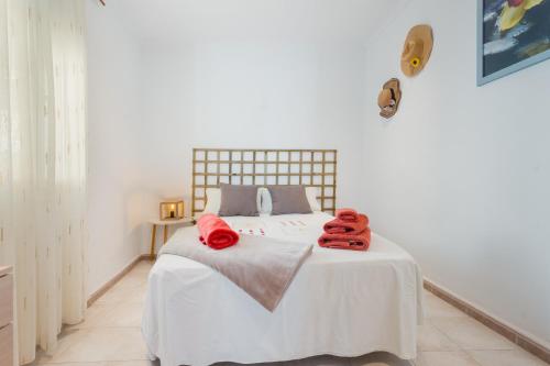 a bedroom with a white bed with red towels on it at Casa Catalán in Carmona
