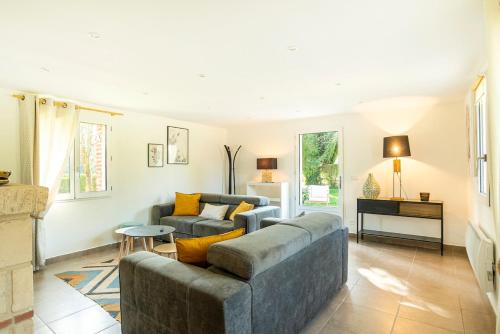 un salon avec un canapé et une table dans l'établissement Superbe maison de campagne aux portes de Deauville, à Pierrefitte-en-Auge