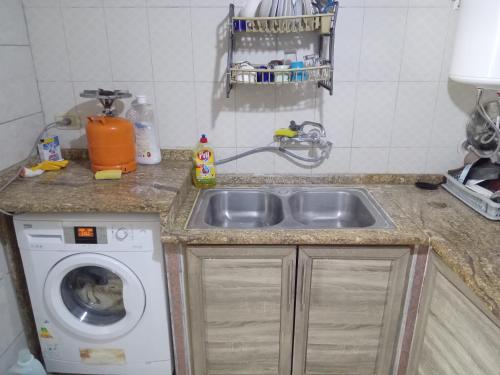 una cucina con lavello e lavatrice di Sky2 a Jerash