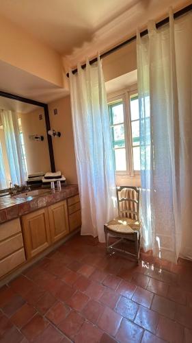 une salle de bain avec un lavabo, un miroir et une chaise dans l'établissement Mas exceptionnel à Lagnes, Provence, à Lagnes