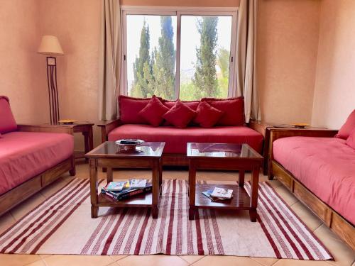 a living room with a red couch and a window at A7 Maison Blanche Imi ouaddar in Agadir