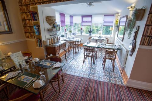 a dining room with tables and chairs and windows at The Ascott in Manchester